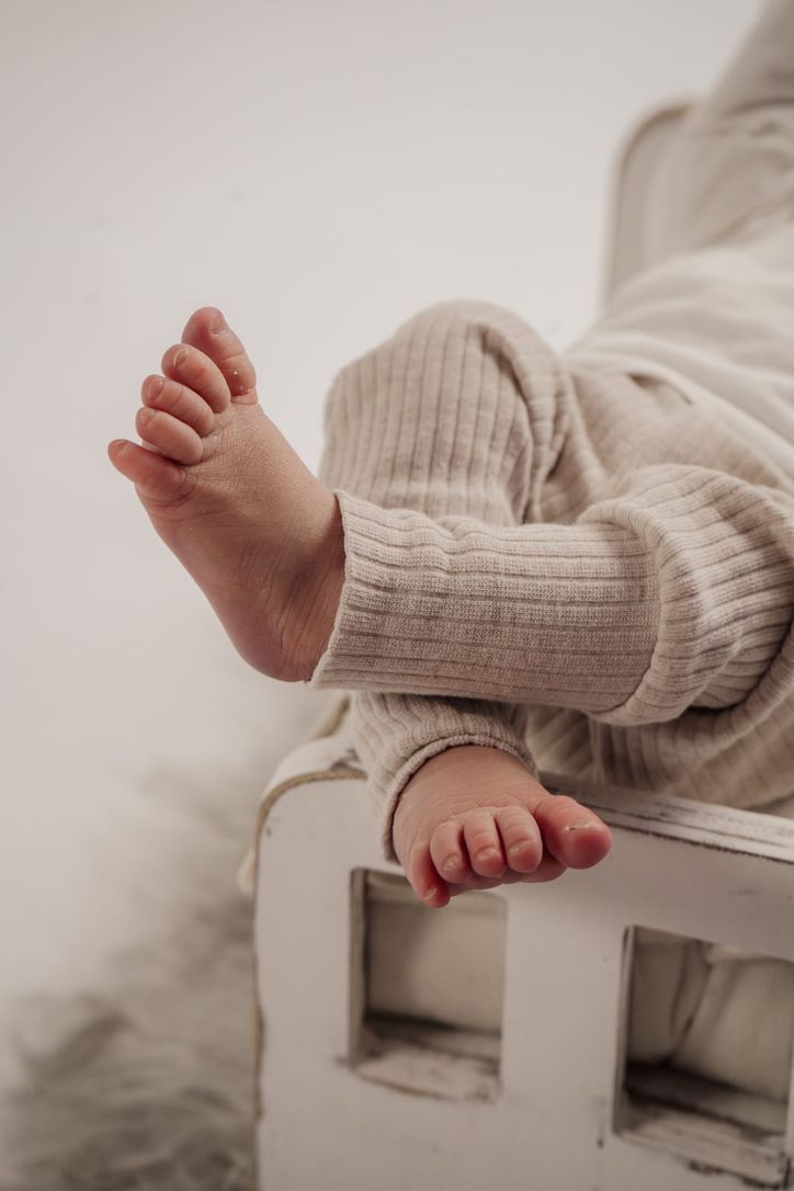 Nahaufnahme winziger Babyfüße im Newbornshooting