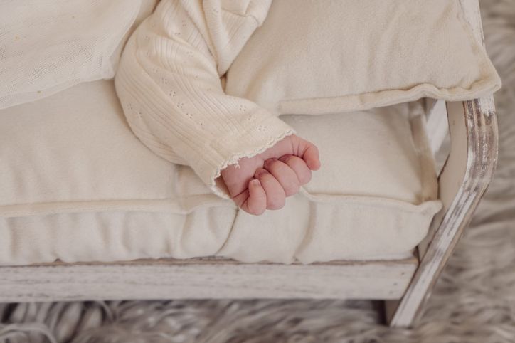 Nahaufnahme der kleinen Hand eines schlafenden Neugeborenen