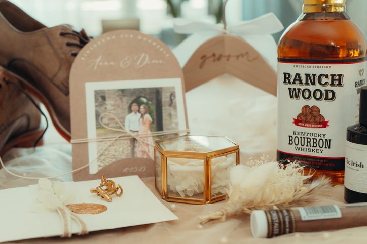 Hochzeitseinladung, Manschettenknöpfe und Geschenke für den Bräutigam auf dem Tisch