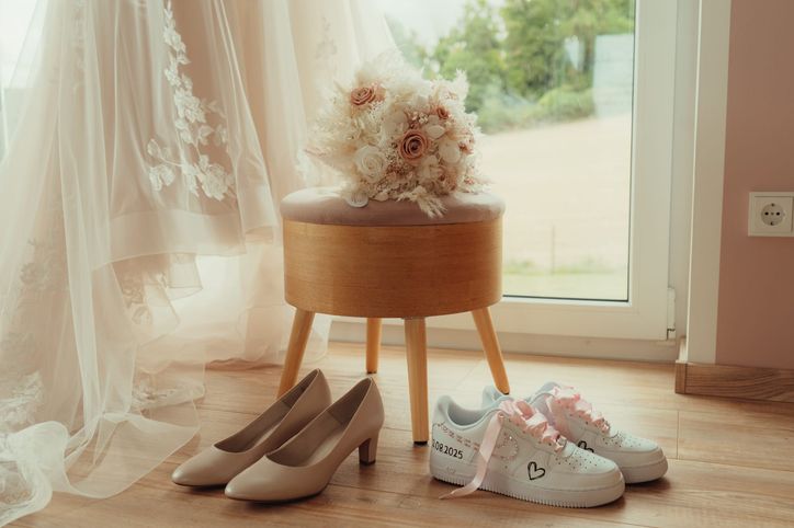 Brautschuhe und personalisierte Sneaker mit Hochzeitsdatum stehen bereit