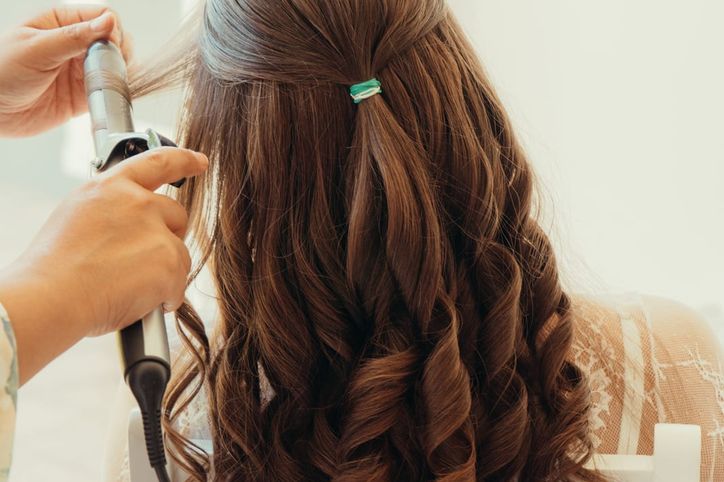 Braut wird beim Ankleiden von ihren Trauzeuginnen unterstützt