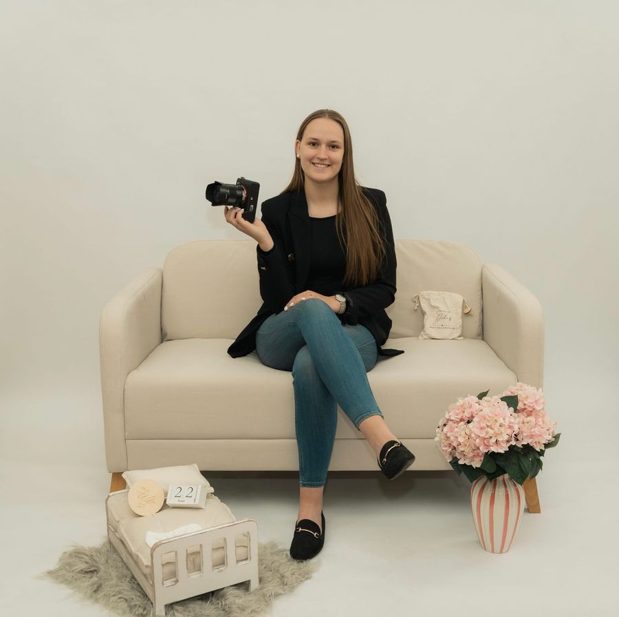 Madeleine Schlegel sitzt mit ihrer Kamera in der Hand im Fotostudio